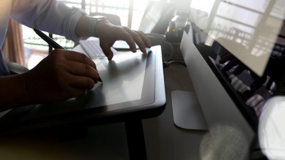 Graphic designer at work in office using a pad and stylus