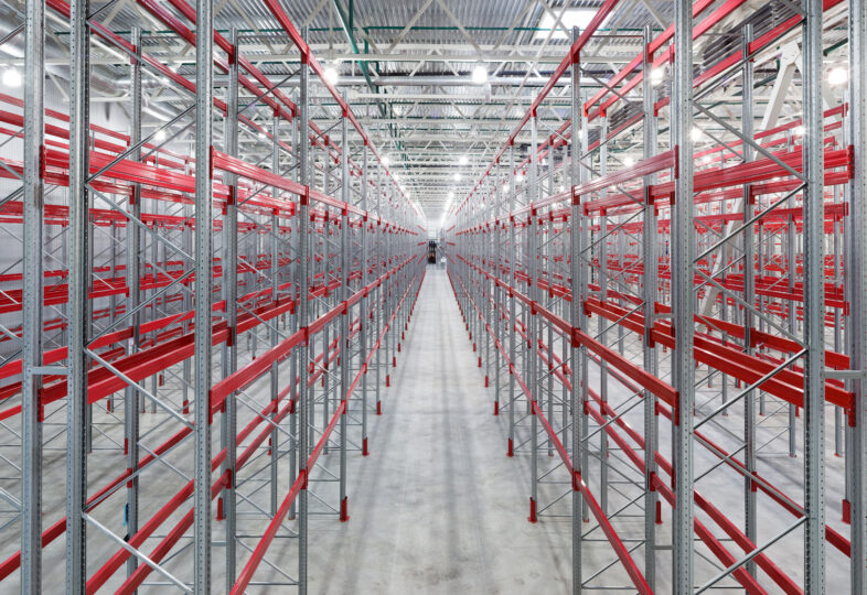 Industrial racks pallets shelves in huge empty warehouse interior